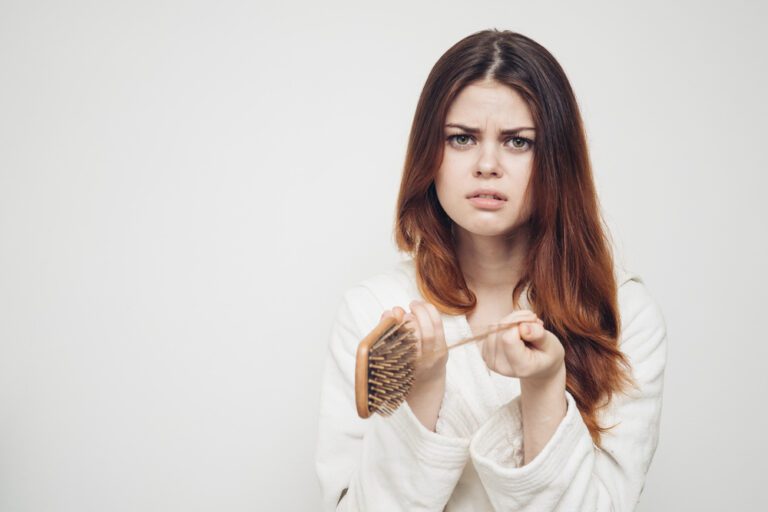 Imagem ilustrativa de mulher com expressão de tristeza e uma escova com cabelos